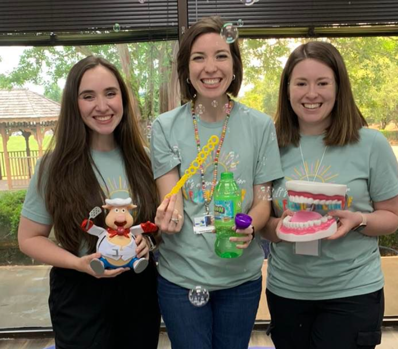 Three therapists holding therapy toys