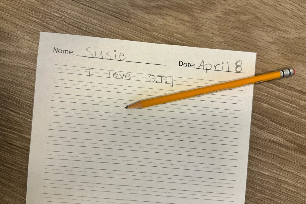 Handwriting sample on lined paper with a pencil