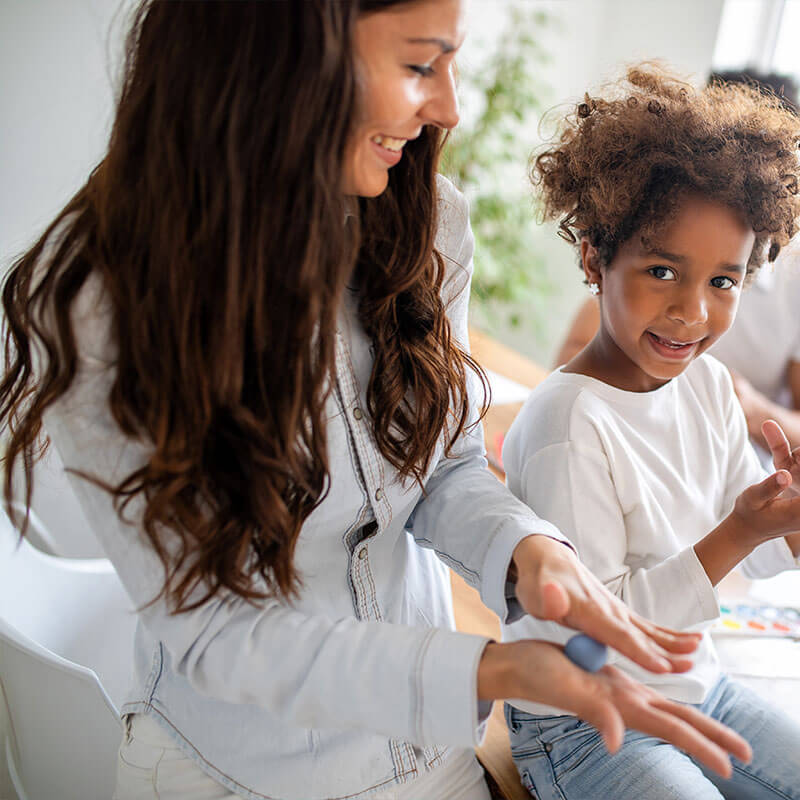Occupational therapy: a therapist working with a smiling girl