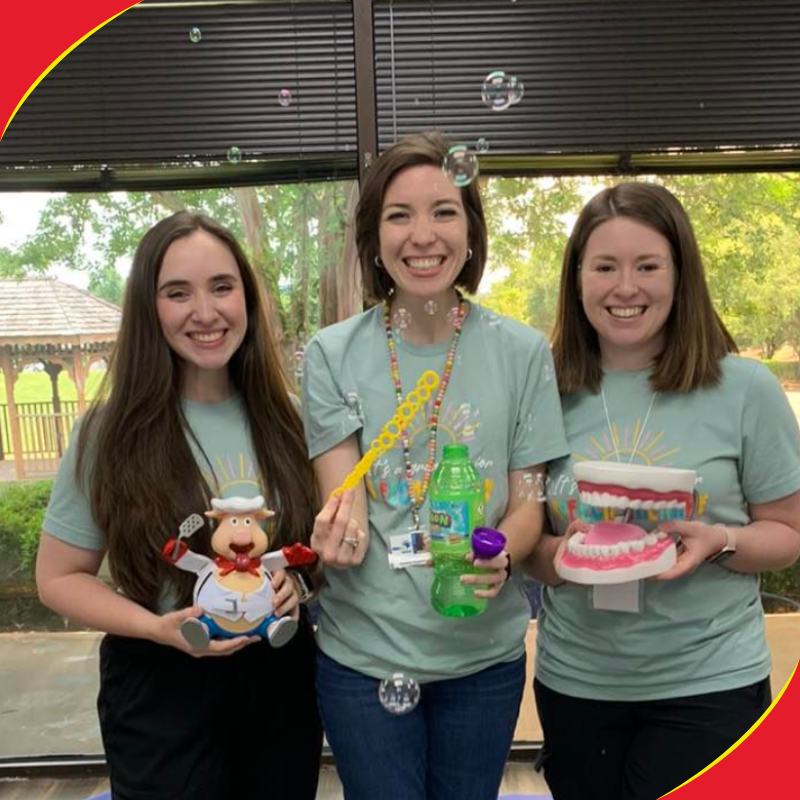 Three speech therapists holding therapy toys