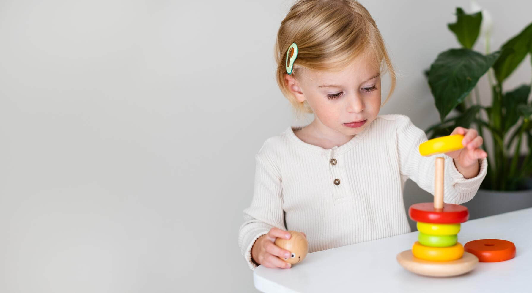 Toddler playing with a stacking ring toy