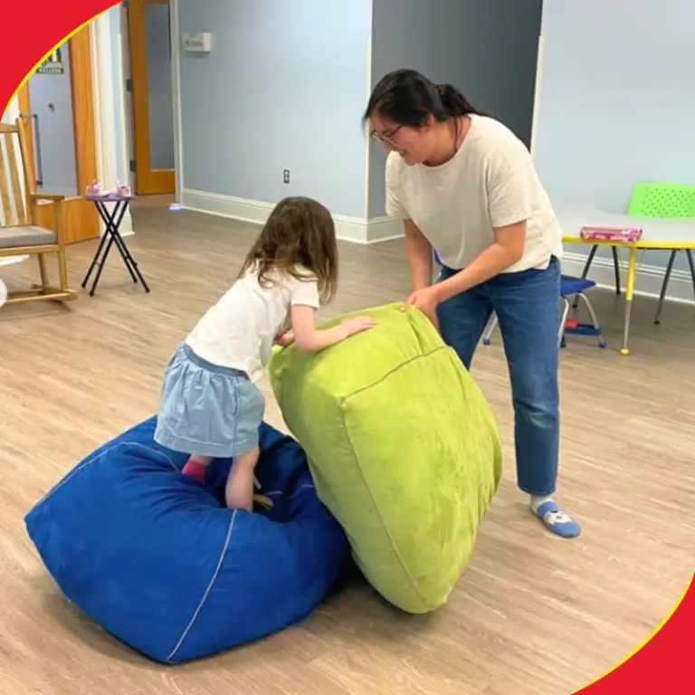 Therapist helping a girl with large bean bag cushions