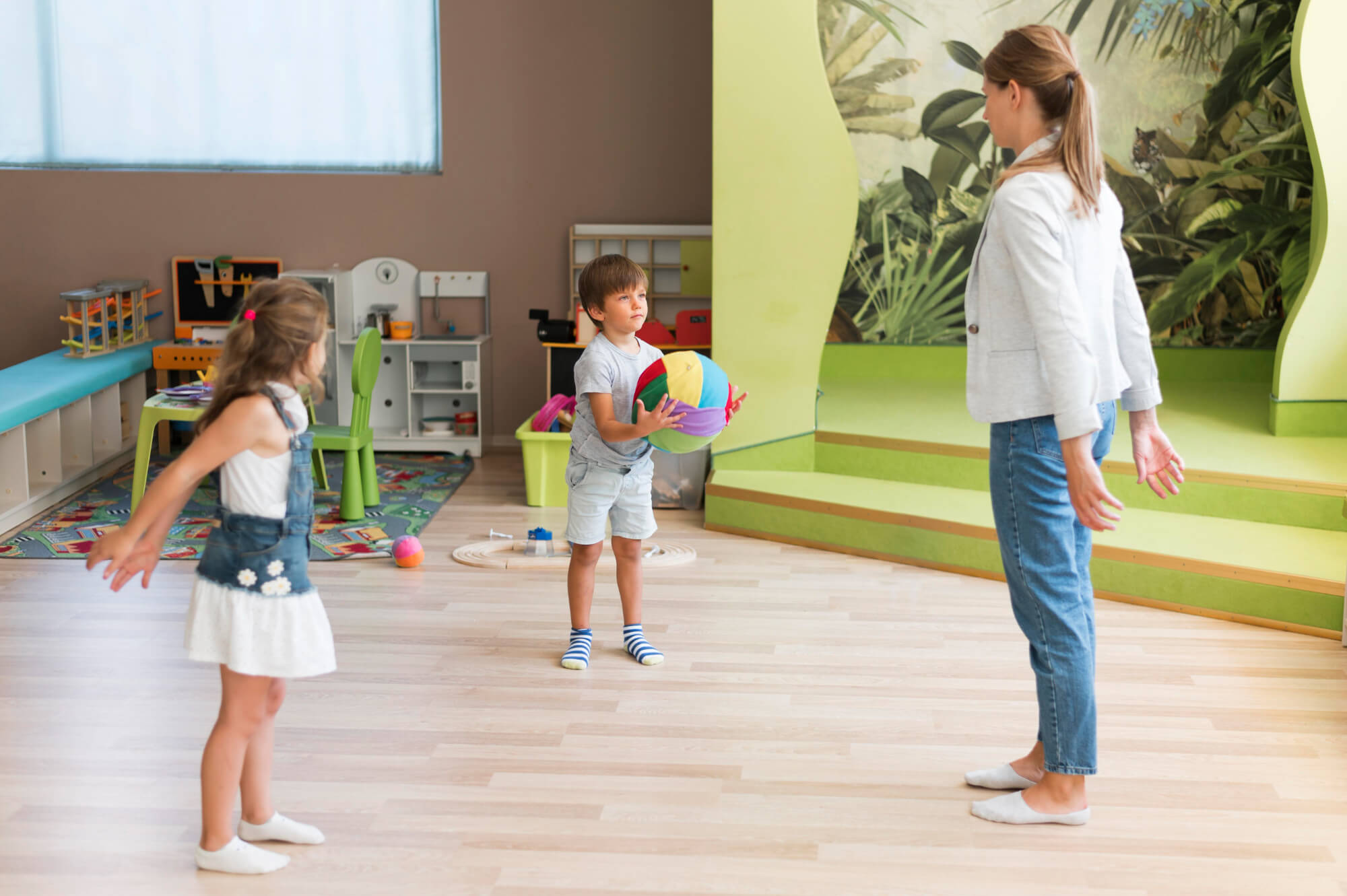 Children playing with balls while an adult watches