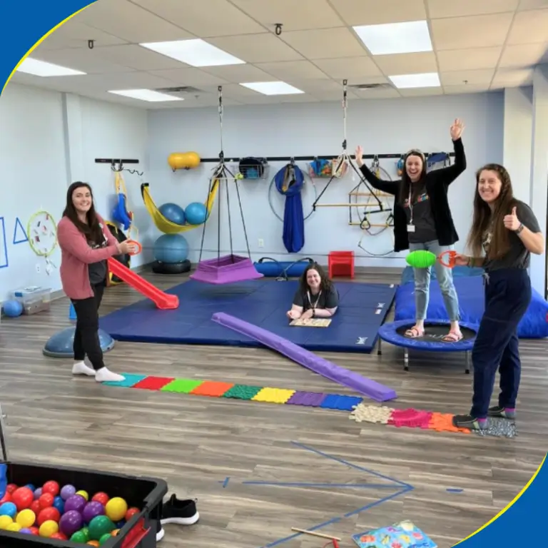 Therapists in a sensory gym with a ball pit and mats