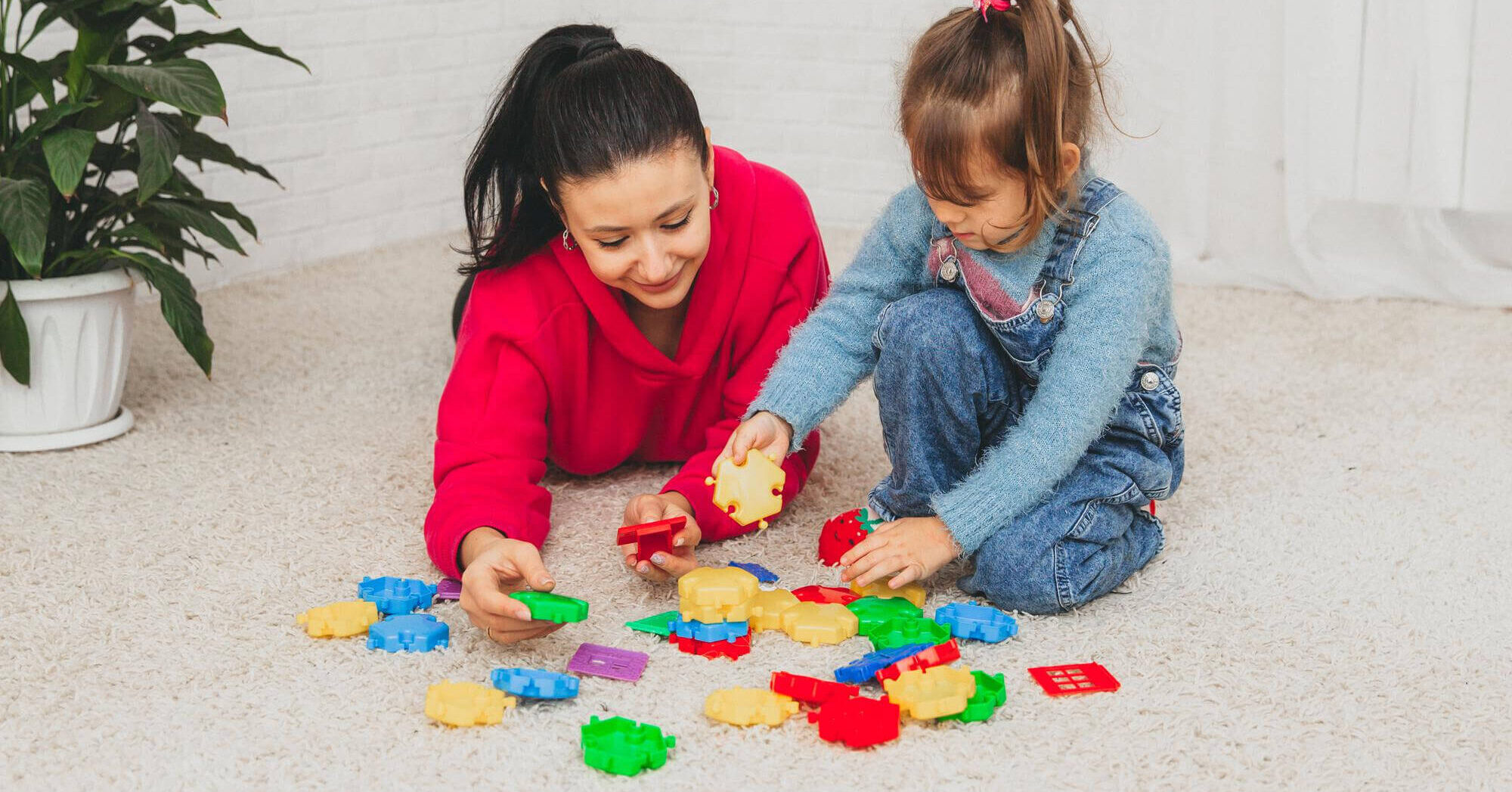 Mother and child playing with colorful puzzle pieces