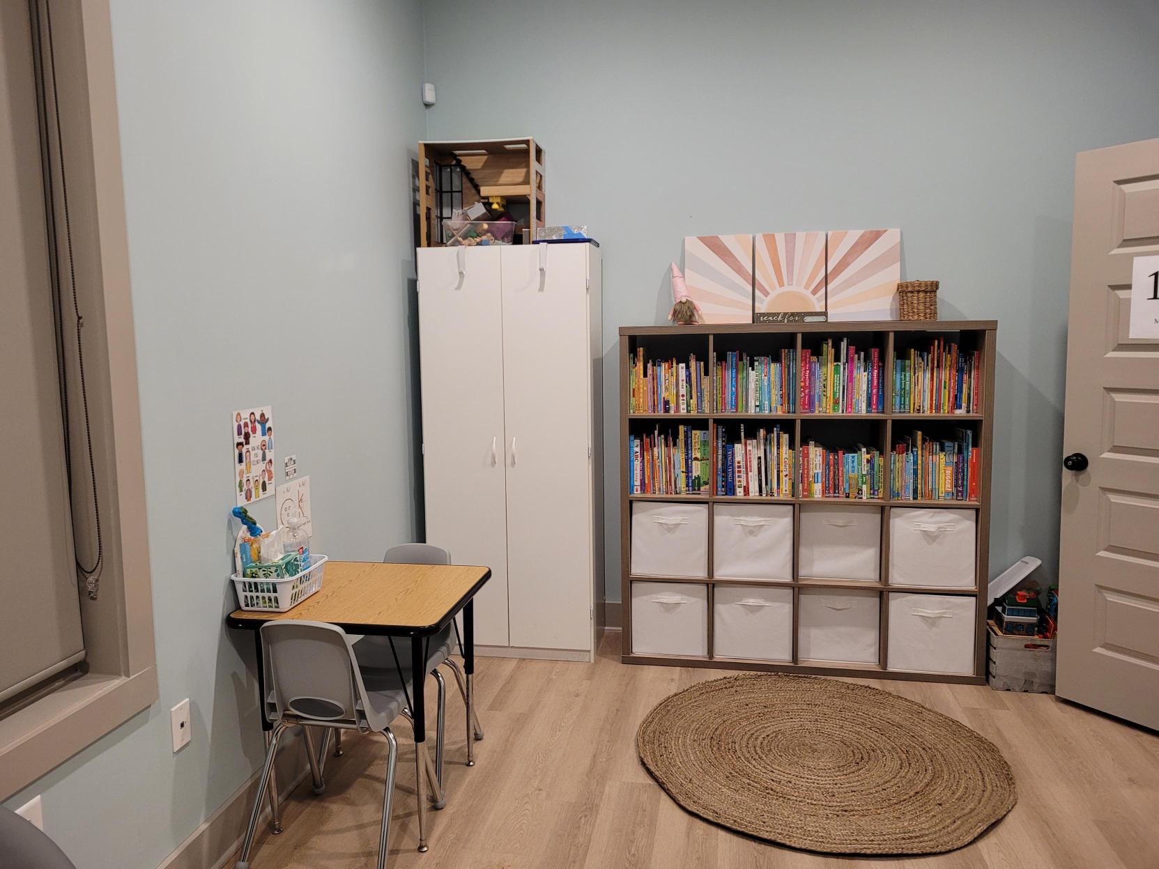 Therapy room with a child-sized table and bookshelf