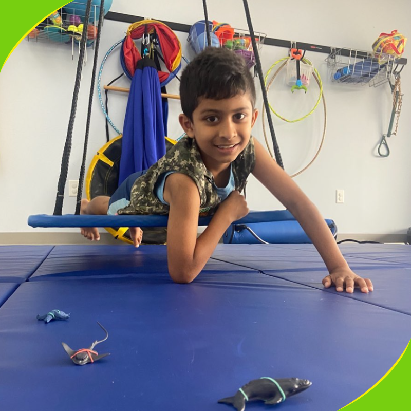 Boy on a therapy swing in a sensory gym