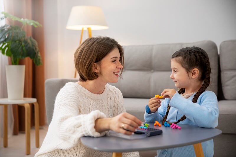 Therapist playing with a girl at a table