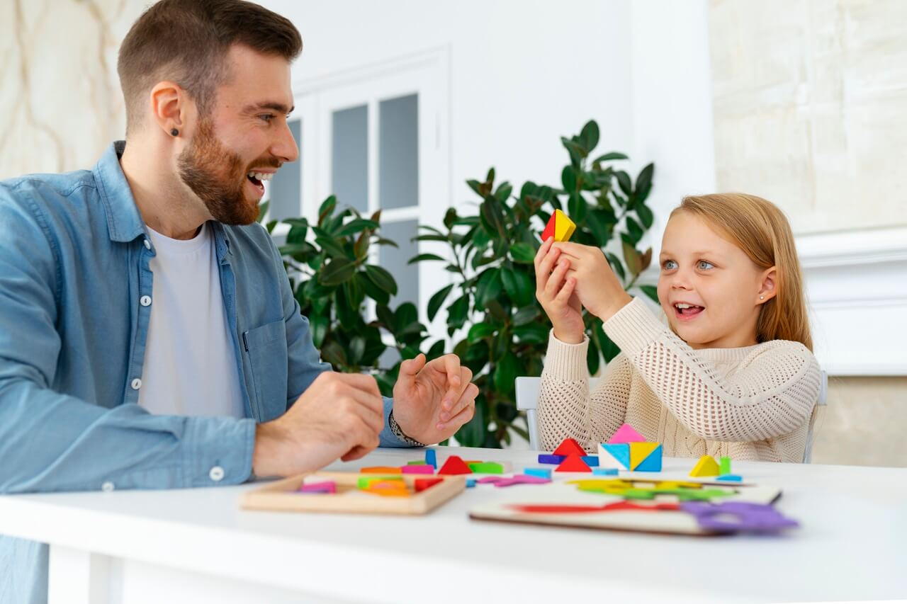 Therapist playing a game with a girl at a table