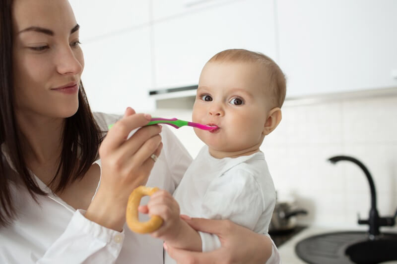 Mother feeding a baby with a spoon