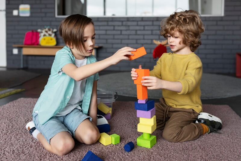 Two children building a block tower